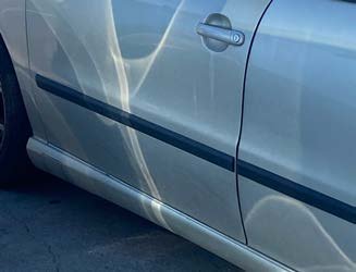 The flank of a car, shine bent along the metal.